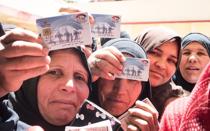 Egyptian women hold cash transfer cards
