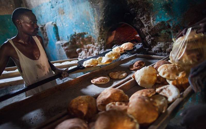 A baker gets the bread from the oven in his bakery in El Fasher, North Darfur.