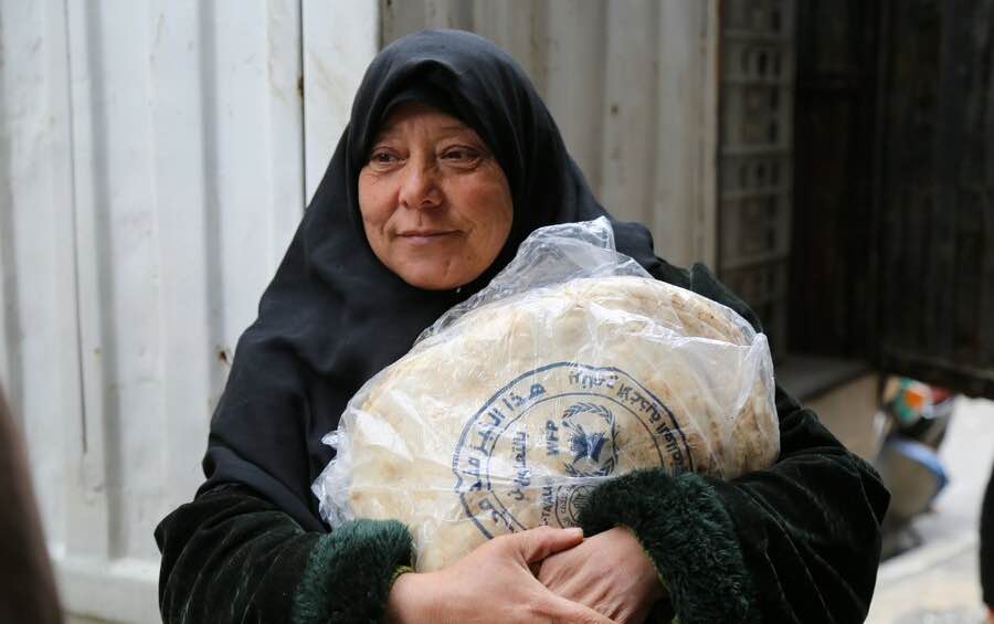 Woman carries bread in Syria