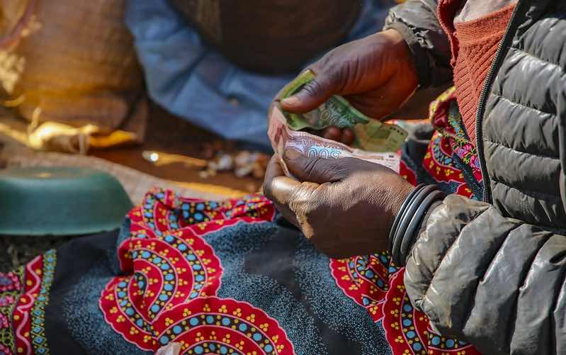 A woman counts cash in a Malawi market