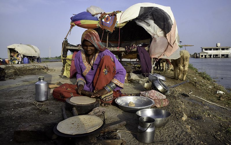 woman cooks next to a shack