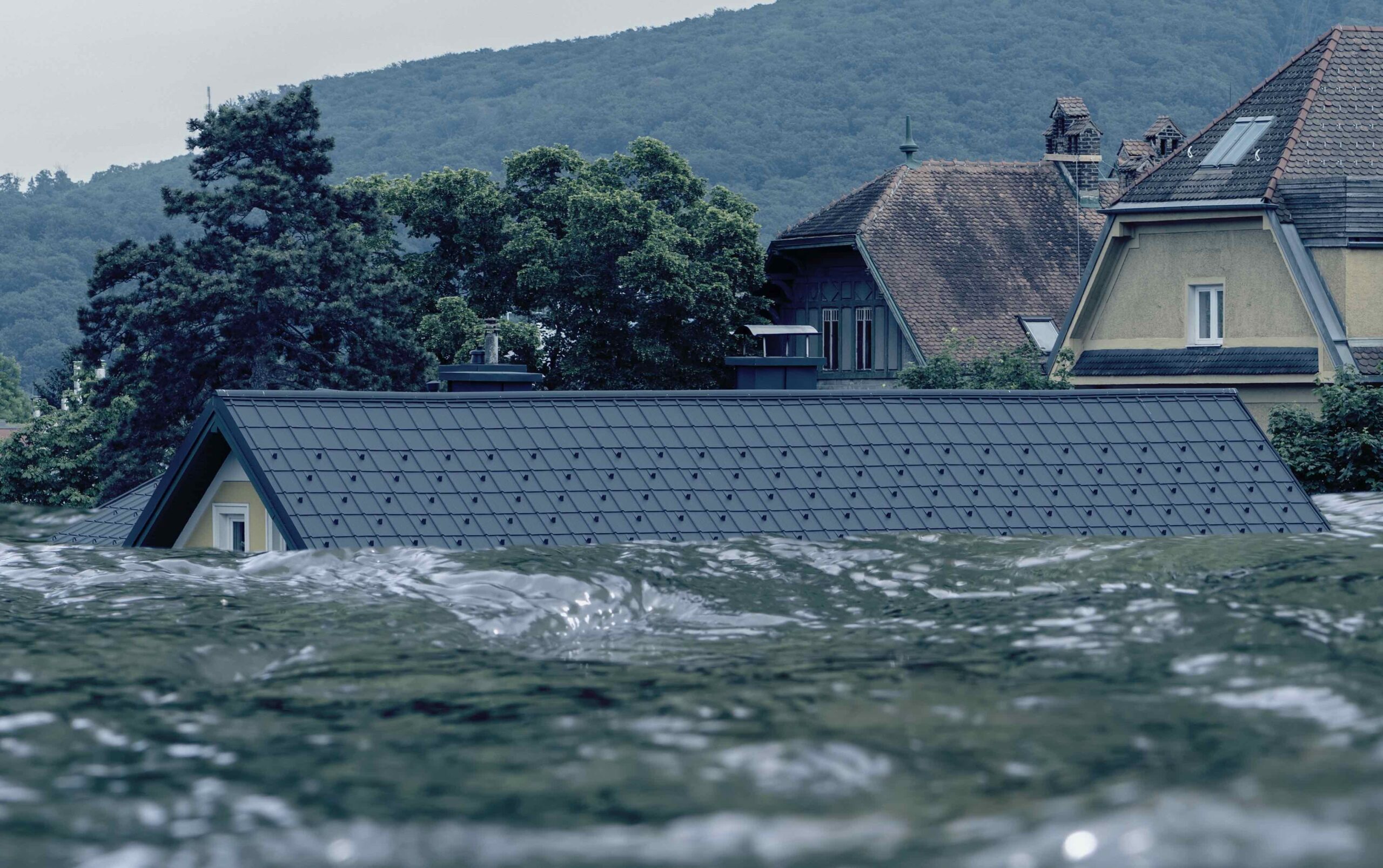 Floodwaters close to the top of the roof of a house